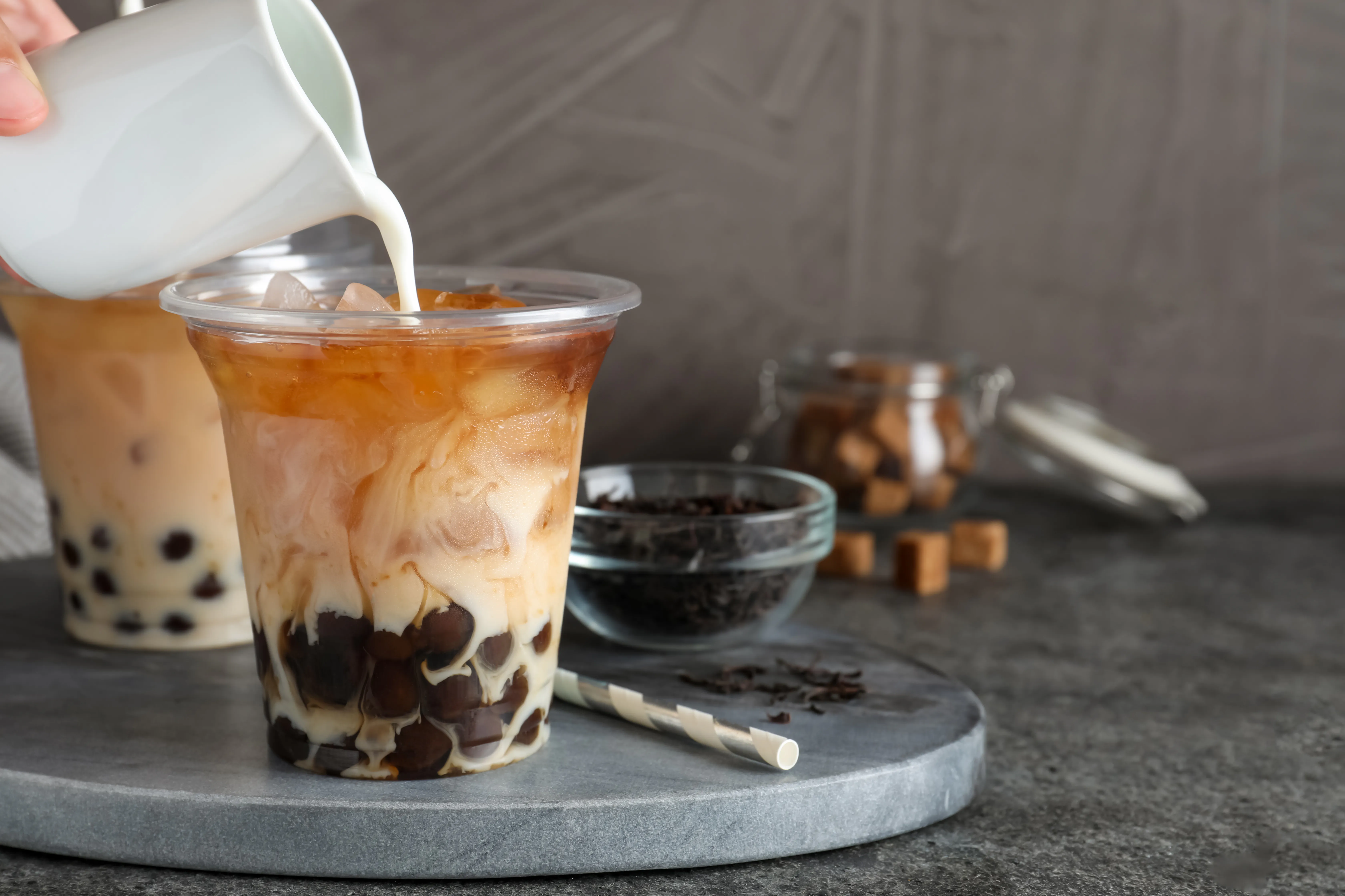 Creamy boba milk tea with tapioca pearls being poured at Tangscape, a Cafe in Forest Hills